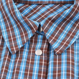Detail of blue and brown checkered shirt collar with a metallic snap button closure