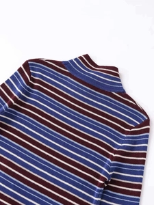 Detail of the knit texture and color-block striped pattern on the boat neck top