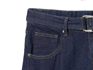 Detail of dark blue denim jeans featuring belt loops, coin pocket and orange contrast stitching