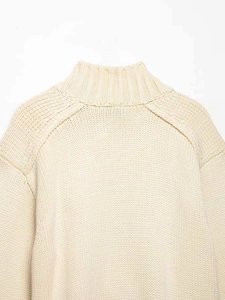 Close-up of cream knit cardigan featuring mock neck design and soft ribbed texture