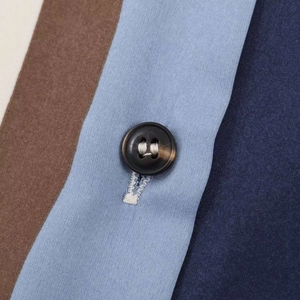 Macro detail of marble pattern button and vertical striped satin fabric on the shirt