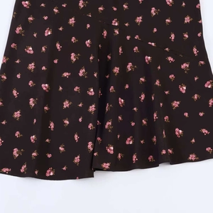 Détail d'une robe midi fleurie avec fleurs roses sur noir et finitions des coutures