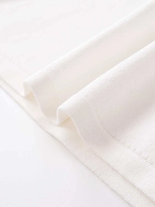 Detailed close-up of breathable white pique knit fabric and double-needle hem stitching