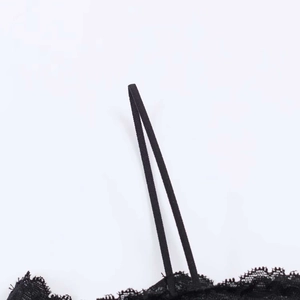 Detail of delicate black lace pattern and thin elastic shoulder straps on the top