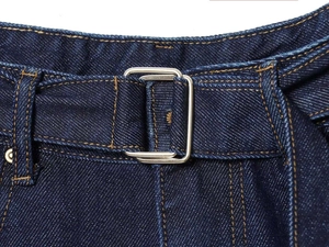 Detail of dark blue denim jeans featuring a double-ring silver buckle and yellow stitching