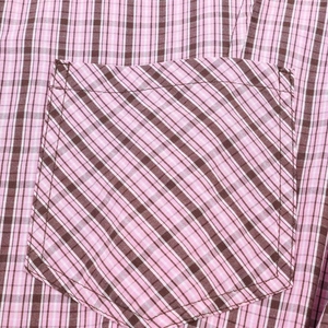 Detailed macro view of the checkered shirt pocket with precise stitching and fabric texture