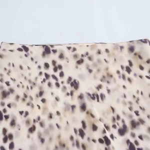 Detailed macro view of the satin animal print fabric showing purple and brown leopard spots