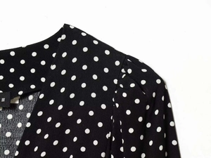 Detail of shoulder seam and neckline on a black polka dot dress with premium stitching