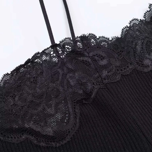 Close-up of the black ribbed knit fabric and delicate floral lace trim on the neckline
