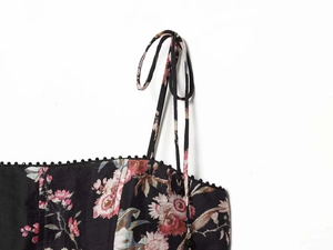 Detailed close-up of floral print fabric with lace trim and tie shoulder straps