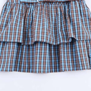Detail view of sky blue checkered tiered dress showing fabric texture and belt