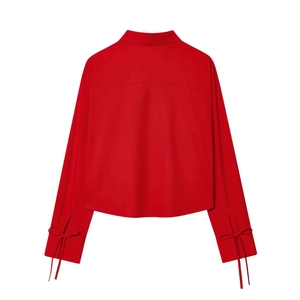 Minimalist bright red long-sleeve shirt for women featuring unique bow-tie cuffs on back view