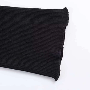 Close-up of black ribbed knit fabric featuring a decorative wavy edge and texture