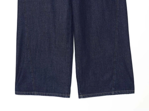 Detailed close-up of dark blue denim wide leg trousers with yellow contrast stitching