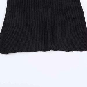 Close-up of black ribbed knit fabric detail featuring delicate lettuce edge stitching