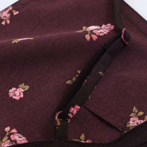 Détail du tissu à fleurs bordeaux avec bretelle réglable et boucle en plastique violette