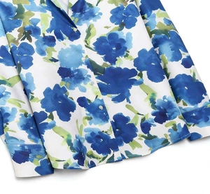 Close-up of white satin blouse featuring watercolor blue floral print and buttons