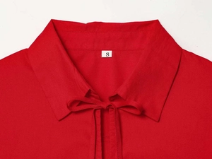 Detail view of a red cotton shirt collar with elegant bow tie-up and size S label
