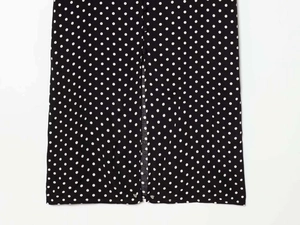 Detailed view of polka dot dress fabric with vertical slit and black button accents