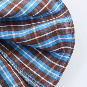 Detail of blue and coffee plaid fabric with high-quality hem stitching on dress hem