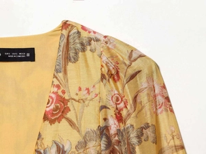 Detail of yellow floral puff sleeve blouse with V-neckline and vintage flower pattern
