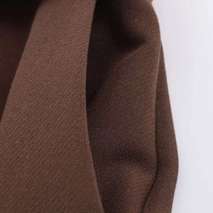 Vista macro dettagliata della trama del tessuto marrone scuro di questi pantaloni larghi