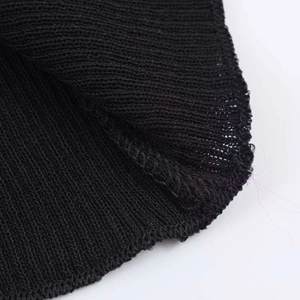 Detail view of the black ribbed knit fabric showing high-quality inner seams and stitching