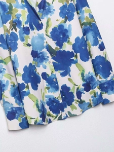 Close-up of blue floral print satin shirt showing white buttons and fine fabric texture