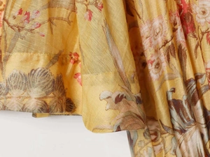 Macro shot of yellow floral print linen fabric showing refined texture and hem detail