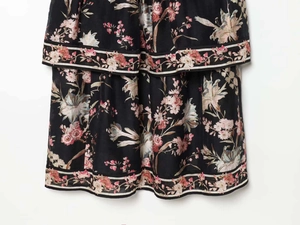 Detailed close-up of floral print and layered hem on black summer dress for women