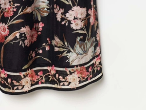 Close-up of floral print dress hem with black fabric and white striped edge detail