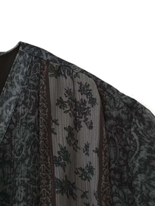 Détail du col en V avec motif paisley floral et texture de tissu plissé fin