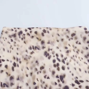 Detailed close-up of smooth leopard print satin fabric with purple and beige patterns