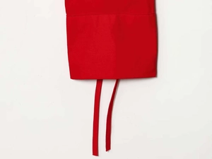Detailed view of vibrant red fabric with sturdy stitching and dual functional ties