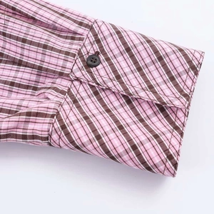 Close-up of the single-button cuff on a pink and brown plaid long sleeve shirt