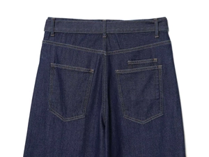 Detail of dark blue denim jeans showing back pockets and yellow contrast stitching