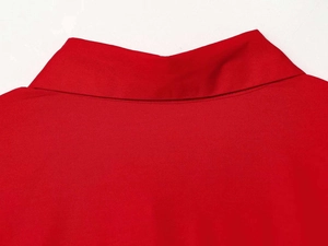 Close-up of red lapel collar showing high-quality stitching and smooth cotton fabric texture