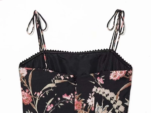 Detailed close-up of floral print fabric with black bead trim and delicate tie straps