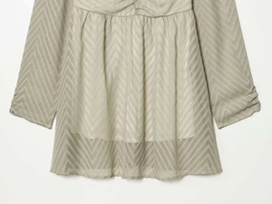 Detail shot of the chevron jacquard texture and fine pleated waist on this green dress