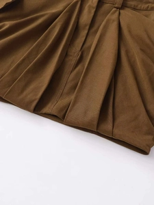 Détail de la jupe cargo plissée marron caramel avec texture sergé et passants de ceinture