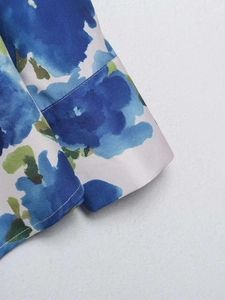 Detail of artistic blue floral print on satin shirt with high-quality sleeve stitching