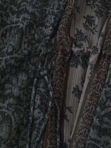 Détail de robe à col en V avec imprimé floral sombre, fils lurex argentés et cordon de serrage