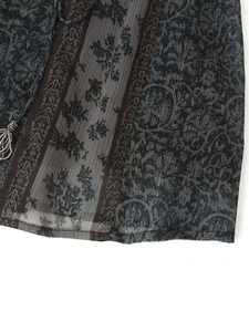 Détail de la texture du tissu avec imprimé floral vintage et perles argentées