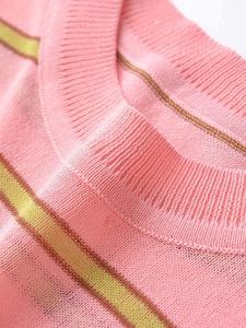 Close-up of the ribbed crew neck and fine green stripes on the pink knit sweater