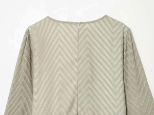 Detail of light green pleated fabric with zigzag texture and invisible back zipper