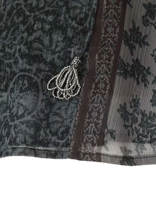 Détail de tissu en maille grise avec imprimés floraux rétro et pompons en perles argentées