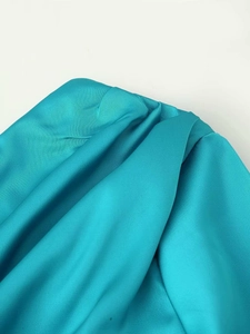 Detailed view of teal satin fabric with elegant drapes and smooth silk texture