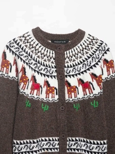 Détail d'un cardigan en maille Fair Isle avec motifs de chevaux et de cactus tissés
