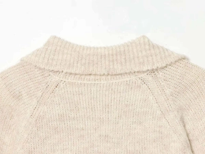 Close-up of knit sweater neck detail with diamond pattern and soft plush texture