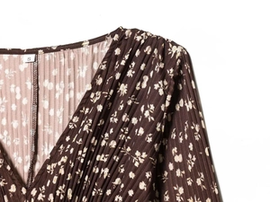 Detail of V-neckline and pleated floral fabric texture on brown summer dress